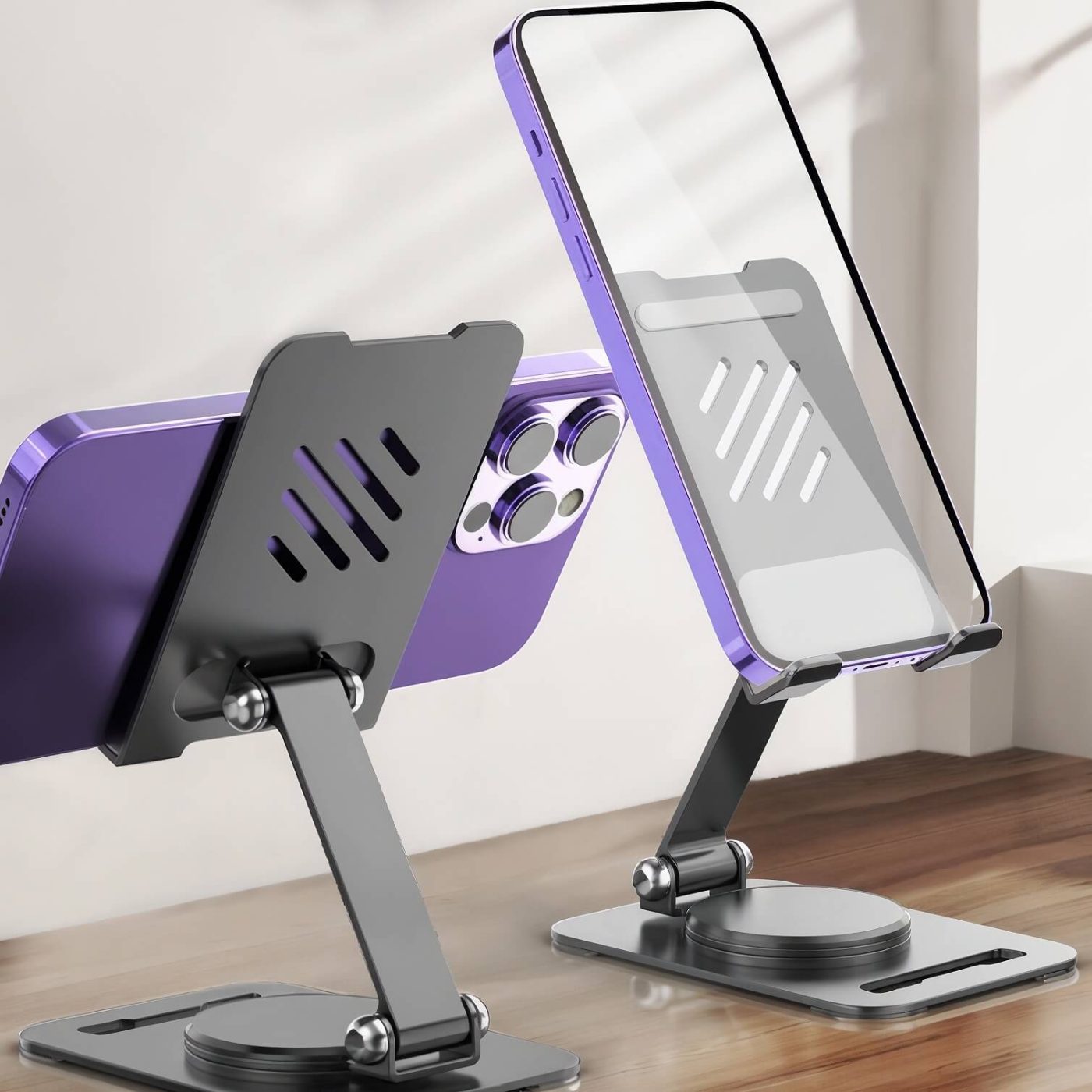 Two black aluminum stands holding smartphones in portrait and landscape mode on a desk