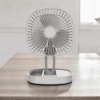 Gray portable folding fan fully extended on a wooden table
