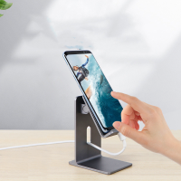 Sleek phone holder in dark gray with a charging cable connected to a smartphone in portrait mode