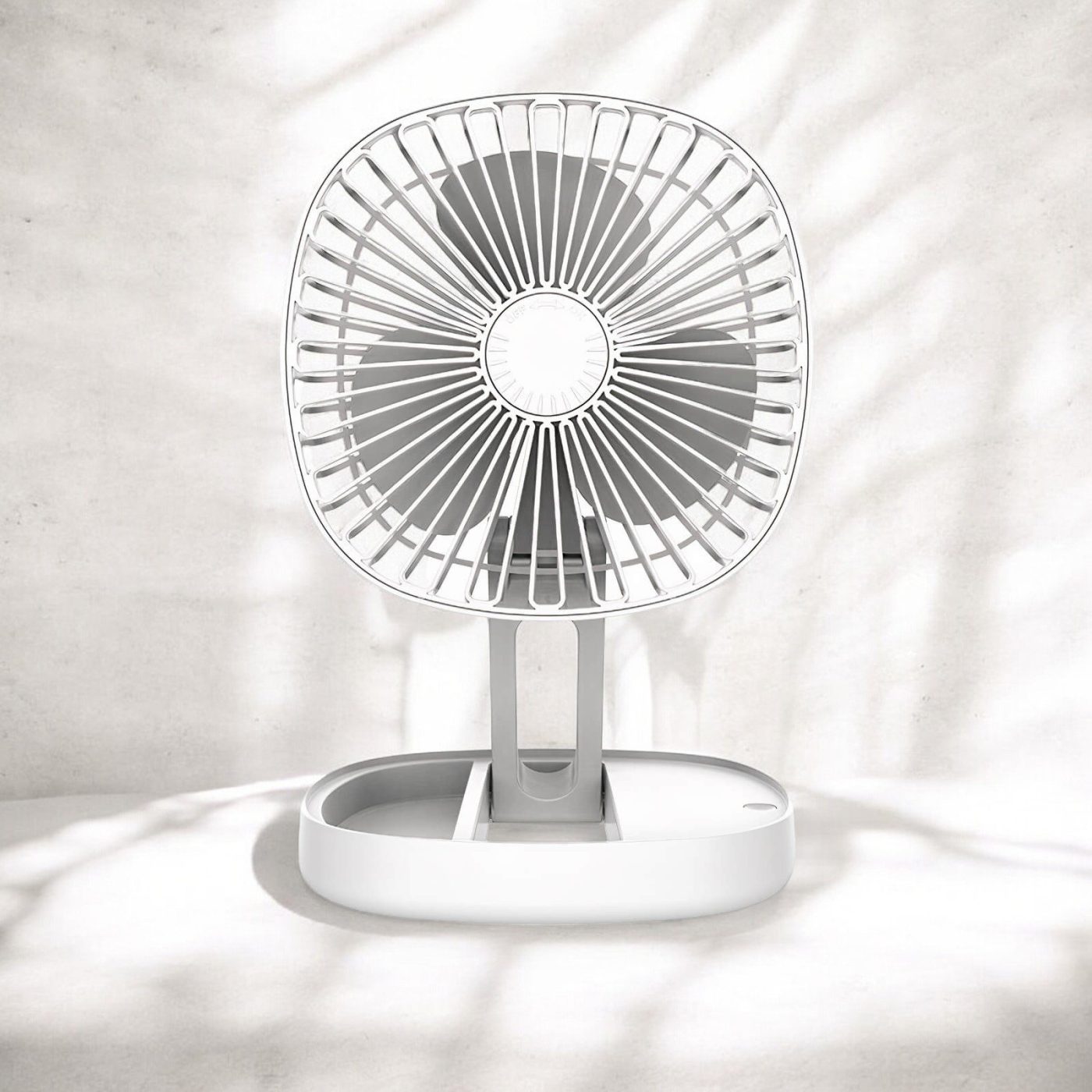 White portable folding fan fully extended with sunlight filtering through