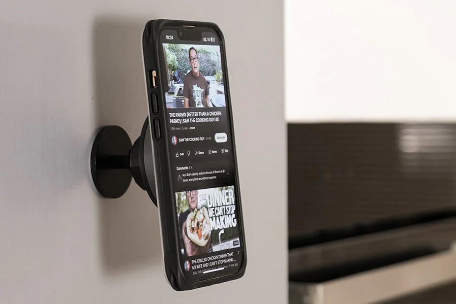 Articulating arm mount Short magnetic mount holding a smartphone displaying social media content attached to a gray wall.