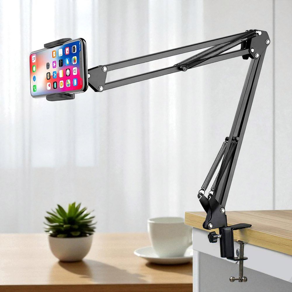 Spring-loaded articulating arm Spring-loaded articulating arm phone mount with joints clamped to a desk edge holding a smartphone at eye level.