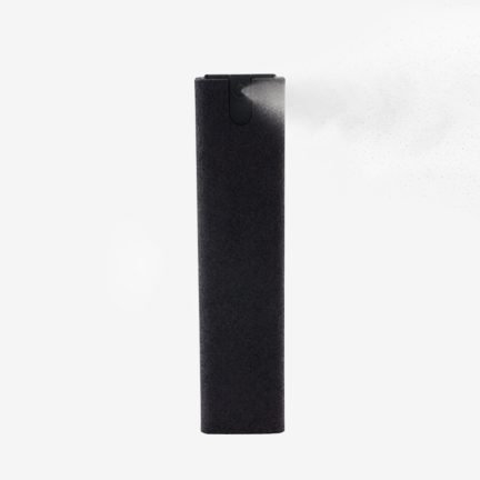 Front view of black phone screen cleaner spray bottle with microfiber sleeve spraying mist.