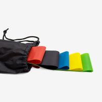 Five resistance bands partially emerging from a black drawstring carry pouch