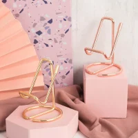 Gold and rose gold phone stands on pink pedestals