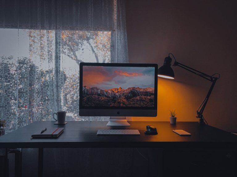 A cozy work from home desk setup with a computer, lamp, and mouse, illustrating essential office items.